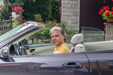 Classy senior sportsman driving cabriolet car