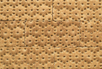 Crisp rye bran bread texture background with brickwork