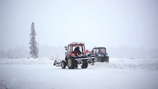 automated snow plows are clearing a road during a snowstorm