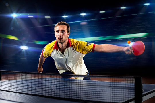 young sports man tennis player playing on black background with