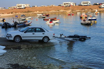 Car with trailer and motor boats in the sea bay at the camp