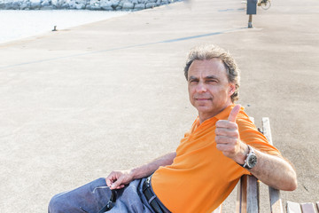 Classy senior sportsman showing thumb up