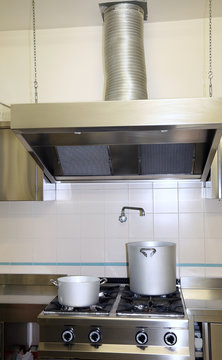 fume Extractor hood in the industrial kitchen with pots on the s