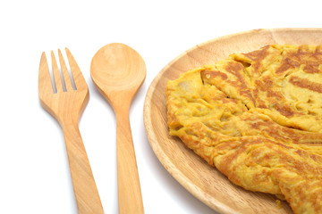 Isolated close up omelet on wooden dish with spoon and fork