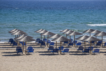Beach with a lot of umbrellas and sunbeds in a sunny summer day, free and ready for the tourists.