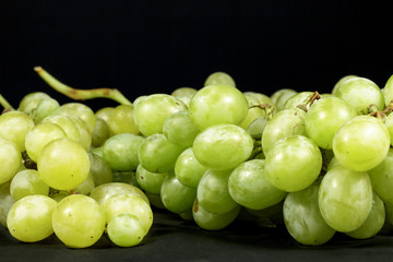 White and green table grapes isolated on black background