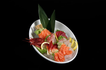 round plate of sushi and sashimi on black