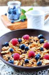 homemade granola with fresh blueberries, raspberries, raisins, milk and honey. Healthy Breakfast
