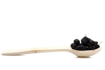 wood background, mulberry in a wooden spoon