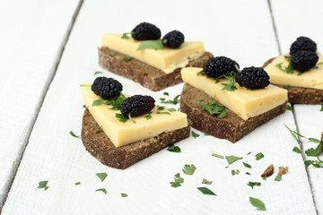 wood background sandwich with cheese and mulberry
