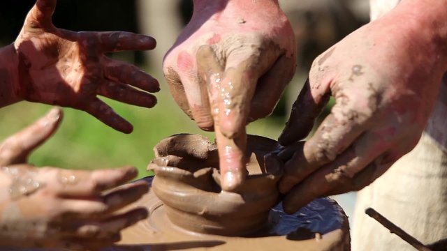 Making clay pottery, hands on wheel close up process