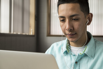 Young man wearing headphones and using a laptop