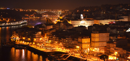 Night scene of Porto with Douro river and old town on hill, Portugal