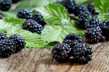 Fresh blackberries with leaves on the old wooden background, sel