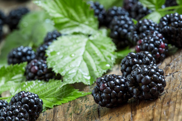 Fresh blackberries with leaves on the old wooden background, sel