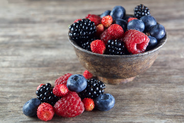 Assorted berries in bowl on wood