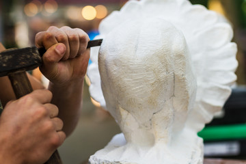 Man carving stone statue