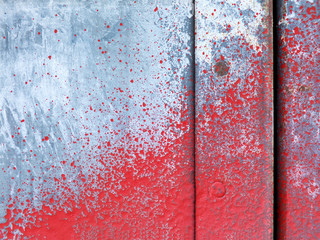 Small part of metal door sprinkled with red paint
