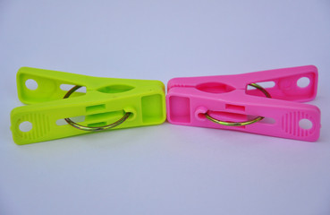 Green and pink clothespins on white background