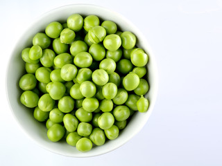 Green peas in the bowl isolated on white 