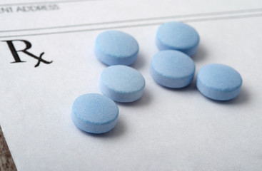 Round Blue Pills Spread Out on a Blank Prescription Form. Medical Theme