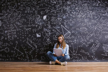 Beautiful young girl in front of blackboard