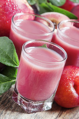 Delicious fresh juice of red and blue sweet plums and peach in a