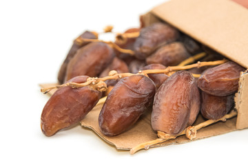 close up of dried dates in paper box  on white background