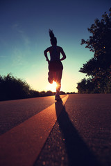 young fitness woman running on sunrise seaside trail 