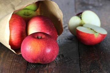 Äpfel der Sorte Elstar in Papiertüte auf Holzhintergrund