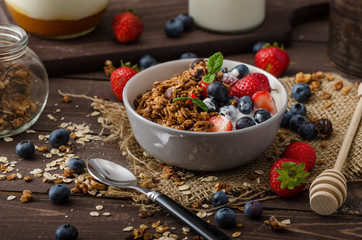 Yogurt with baked granola and berries in small bowl
