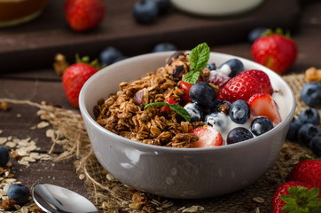 Yogurt with baked granola and berries in small bowl - 88887162