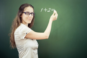 Teacher or student wrote on blackboard with chalk at classroom