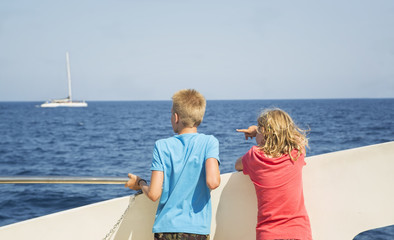Fototapeta na wymiar Children look at the sea from the boat deck