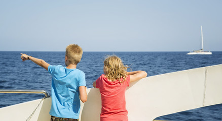 Fototapeta na wymiar Children look at the sea from the boat deck