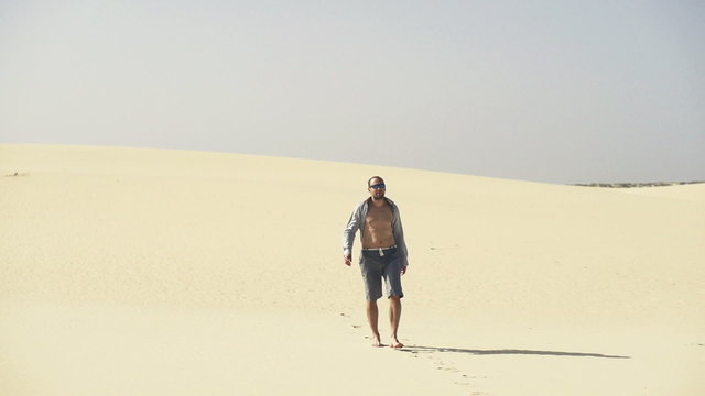 Lost, young man walking on desert
