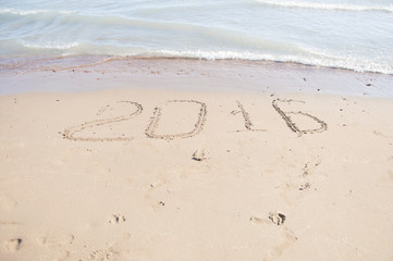 2016 written in sand on sunny beach