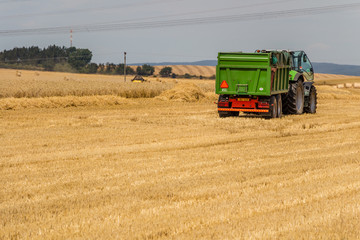 Fototapeta premium Truck preparing to load hay bales on a field during harvest time 