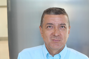 Portrait of mature middle eastern businessman smiling inside office building