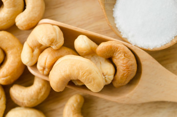 cashew and salt in wooden spoon.