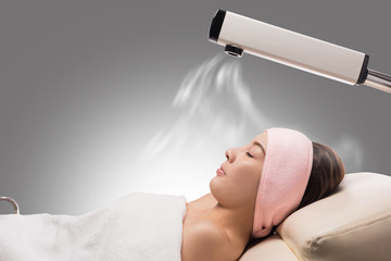 Beauty treatment of face skin with ozone facial steamer in spa center , asian women facing the steam. Steam for smooth skin - obrazy, fototapety, plakaty