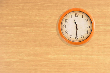Clock showing 11:30 o'clock on a wooden wall