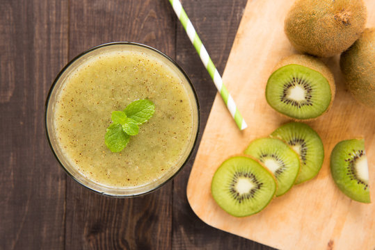 kiwi smoothie with fresh fruits on wooden background. Top view