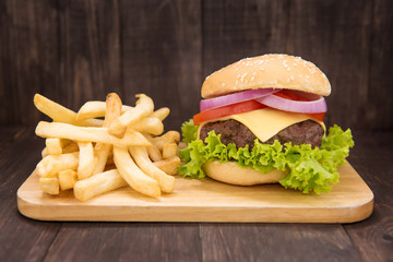 Cheeseburgers with french fries on wooden background