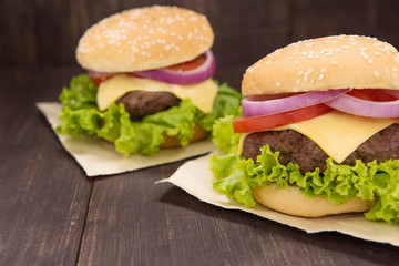 Cheeseburger on buns with succulent beef on the wooden backgroun