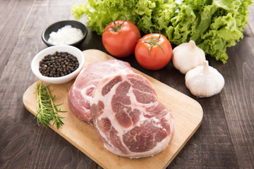 Raw fresh meat and vegetables on wooden background