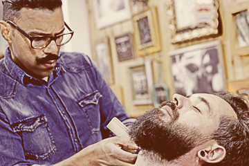 young customer on a beard shaving session.