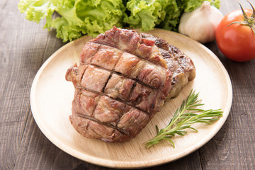 Grilled beef steak and vegetable on a wooden background