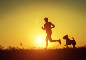 Silhouette of runner with dog  in sunset rise