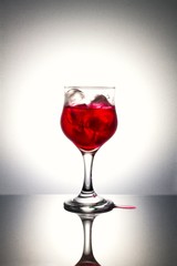 Red syrup on ice with gray background.Used color tool.
